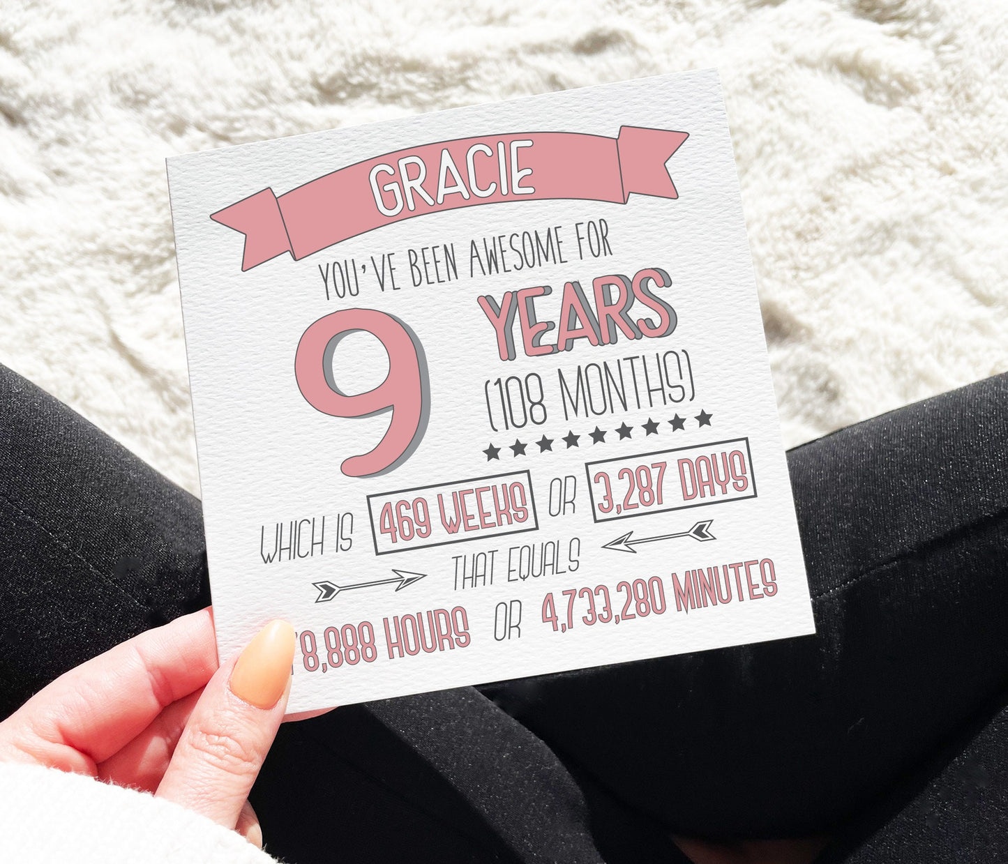 A personalized 9th birthday card with text that calculates and displays the time in years, months, weeks, days, hours, and minutes, held in a hand.