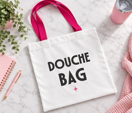 White tote bag with bright pink handles. Large black text saying 'douche bag' and our pink sparkle.