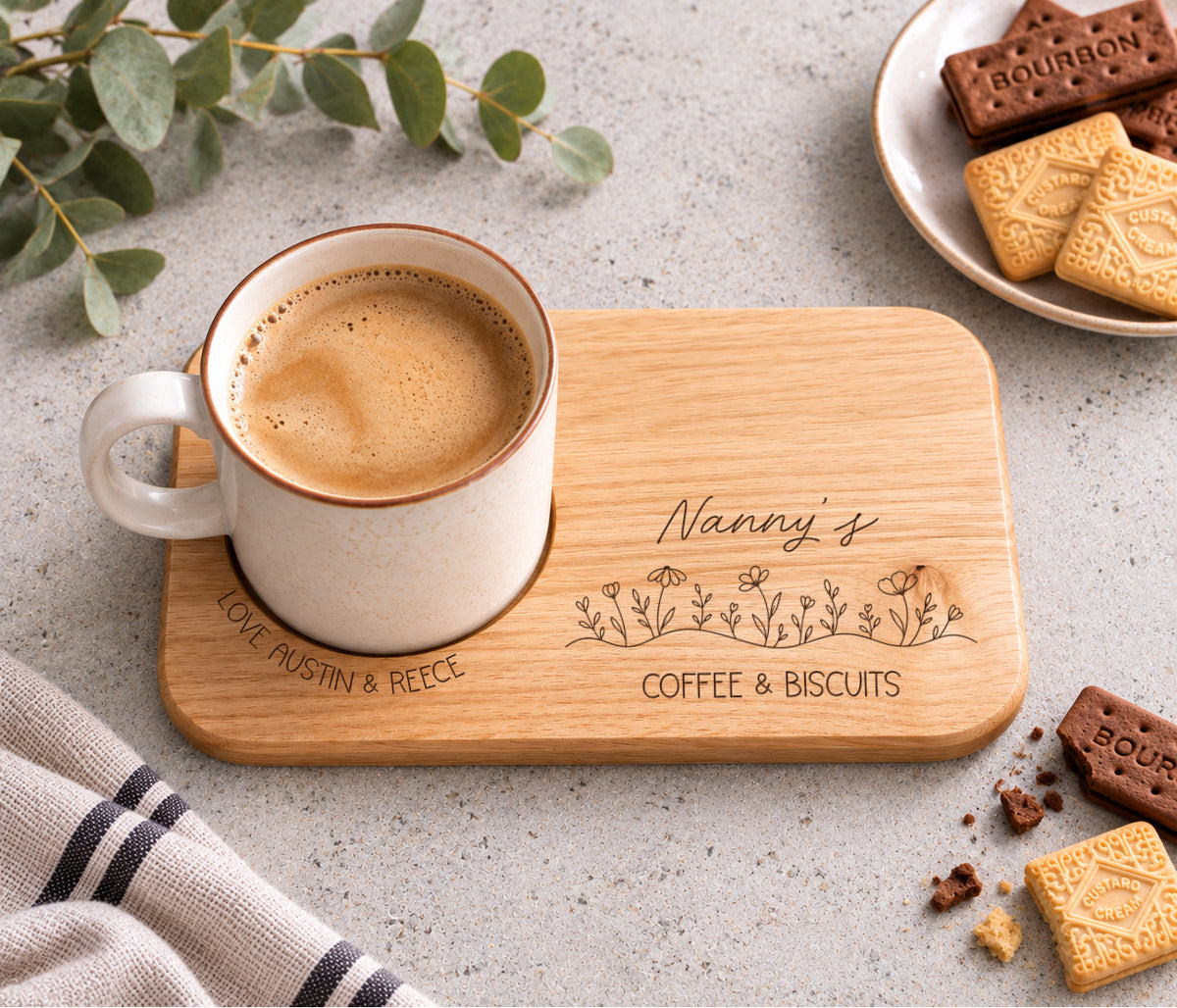 A rectangular wooden serving tray engraved with 'Nanny's coffee & BISCUITS' and a line of wildflowers, with love and the child / childrens name wrapped around the mug indent.