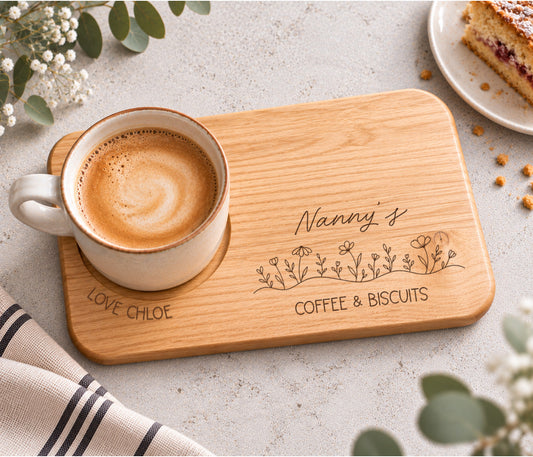 A rectangular wooden serving tray engraved with 'Nanny's coffee & BISCUITS' and a line of wildflowers, with love and the child / childrens name wrapped around the mug indent.