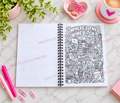An open spiral notebook on a marble surface, with the right page filled with dense black line-art doodles and the phrase “WHERE’S THE WINE BITCH?” The left page is blank with faint sketch outlines. Pink pens, paperclips, a plant, a cup of coffee, and other stationery props surround the notebook.
