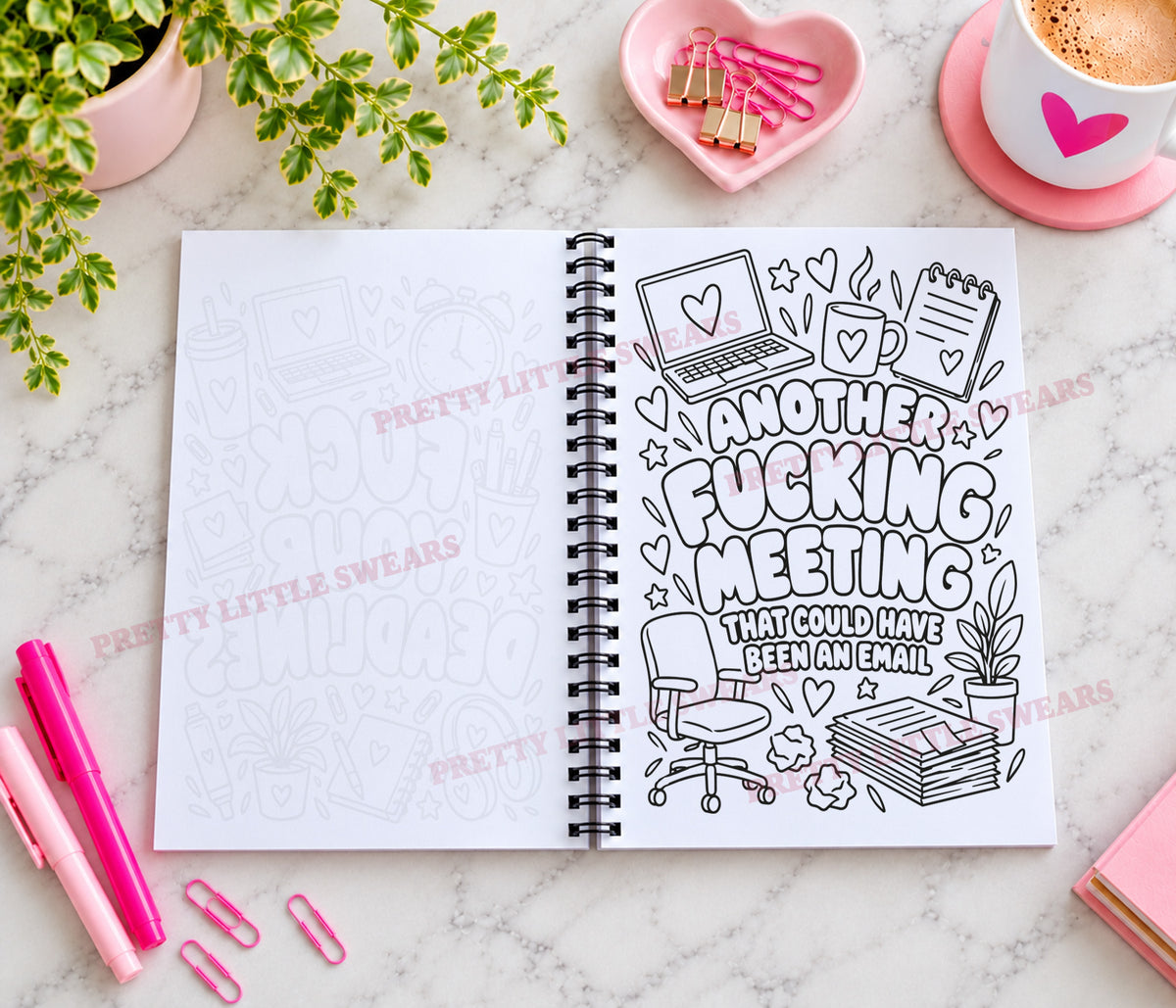 A spiral-bound rude work themed notebook lies open on a marble surface, showing a black-and-white doodle-style cover design with the text 'ANOTHER FUCKING MEETING THAT COULD HAVE BEEN AN EMAIL.' Pink pens, paperclips, a plant, and a coffee cup are arranged around it as styled props.