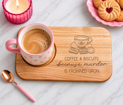 A wooden coffee and biscuit tray with engraved text 'coffee and biscuits because murder is frowned upon' and a teacup illustration.