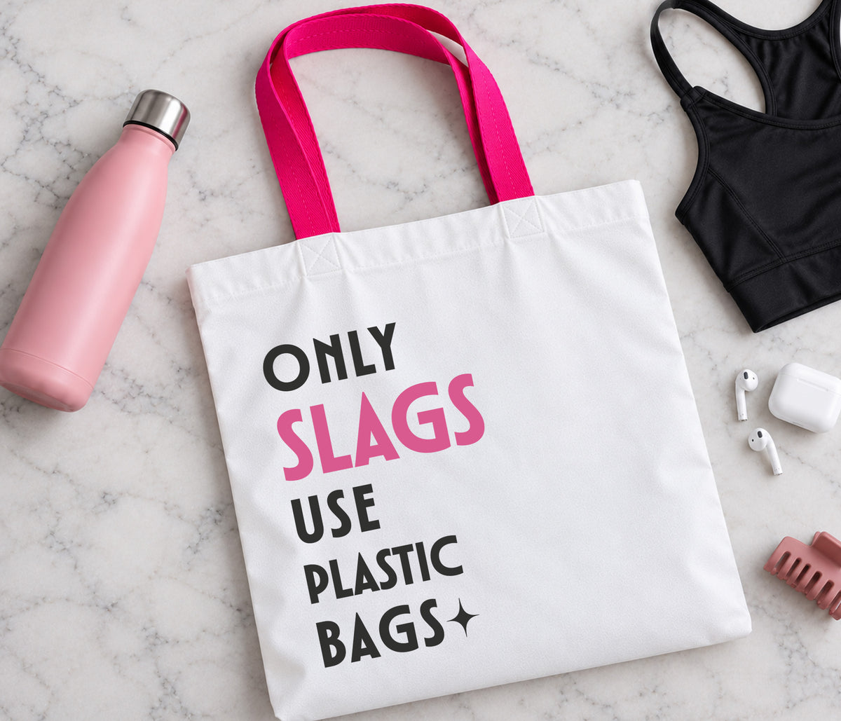 White tote bag with bright pink handles. The text on the bag reads only slags use plastic bags.